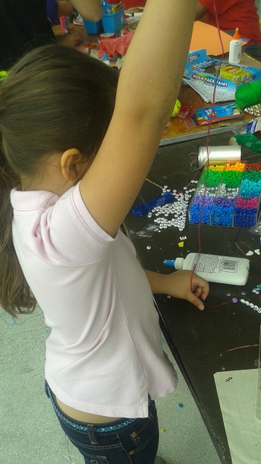 Isabella Making a "Friends"necklace at the Delray Beach Open Kidz Day