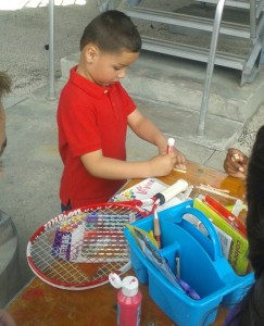 Joaquin making a clothespin creature at Delray Beach Open Kidz Day